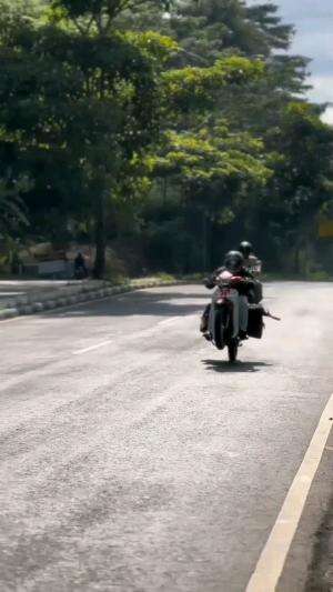 kurir sedang menyetting motor agar cepat sampai tujuan 