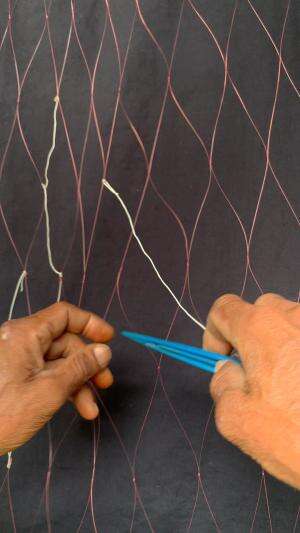 mempebaiki jaring ikan yang rusak