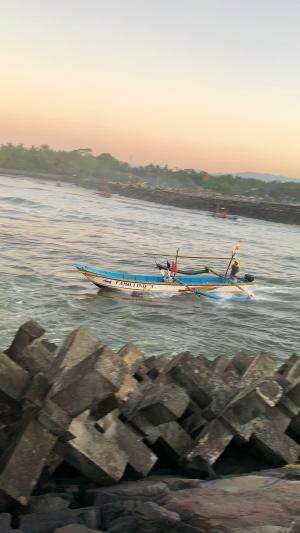 rombongan perahu nelayan melewati muara cikidang