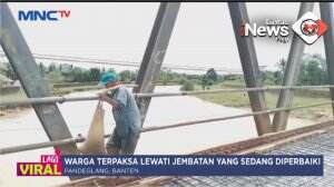 Warga Lewati Jembatan Diperbaiki