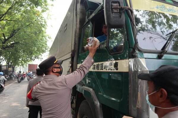 Jalur Pantura Gresik Macet Total, Kapolsek Manyar Bagikan Nasi Bungkus dan Air Mineral