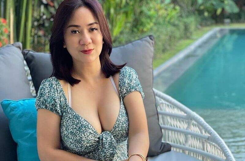 Tante Ernie Pakai Tanktop Biru Laut Berpose di Jembatan, Keliatan Segar Deh